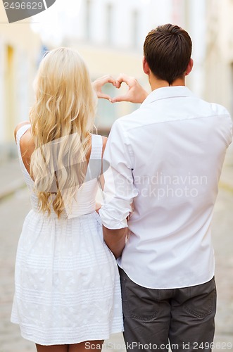 Image of romantic couple in the city making heart shape