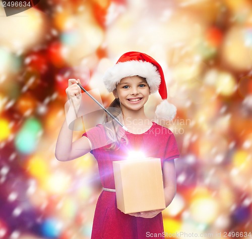 Image of smiling girl in santa helper hat with gift box