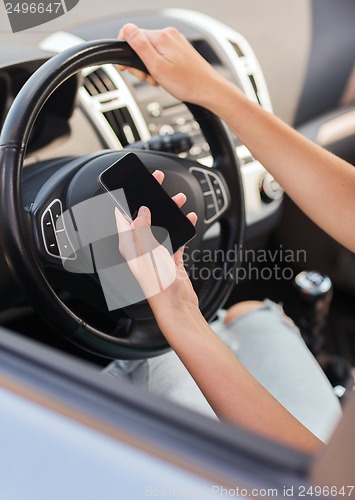 Image of woman using phone while driving the car