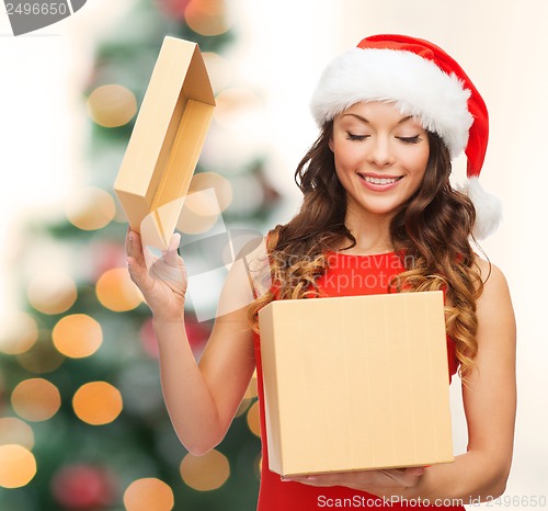 Image of smiling woman in santa helper hat with gift box