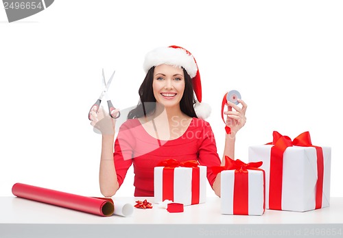 Image of woman in santa helper hat with many gift boxes