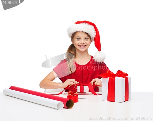 Image of smiling girl in santa helper hat with gift box
