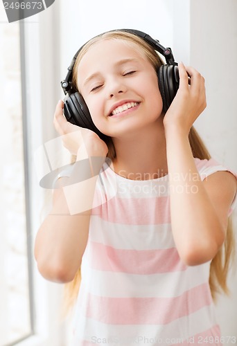 Image of little girl with headphones at home