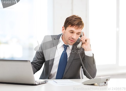 Image of businessman with laptop computer and phone