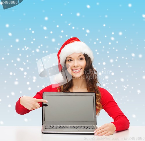 Image of woman in santa helper hat with laptop computer