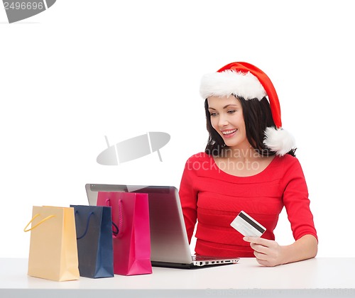 Image of woman with gifts, laptop computer and credit card