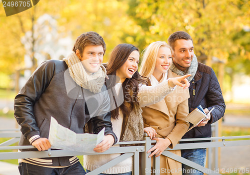 Image of couples with tourist map in autumn park