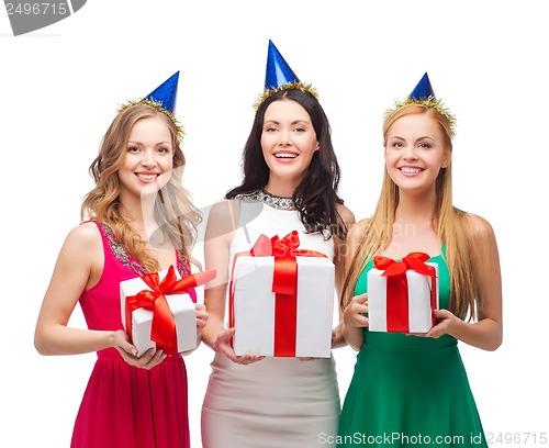 Image of three smiling women in blue hats with gift boxes