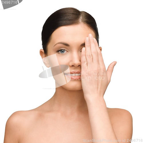 Image of smiling young woman covering face with hand
