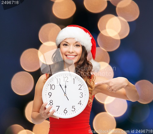 Image of woman in santa helper hat with clock showing 12