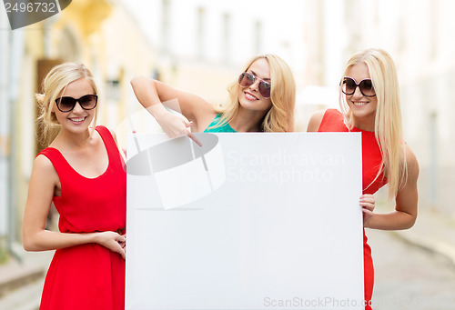 Image of three happy blonde women with blank white board