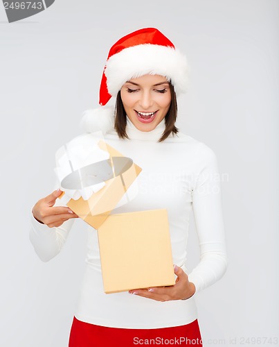 Image of surprised woman in santa helper hat with gift box