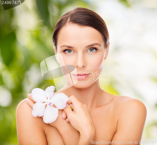 Image of relaxed woman with orchid flower