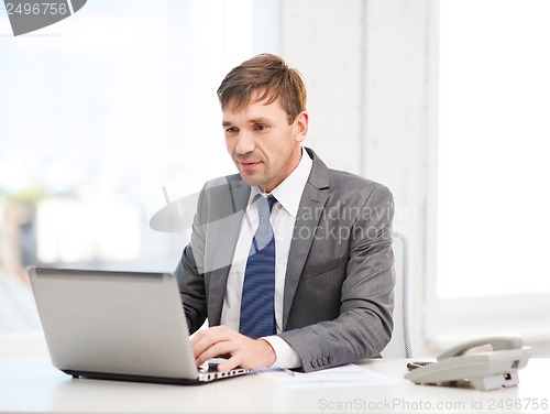 Image of businessman with laptop computer and documents