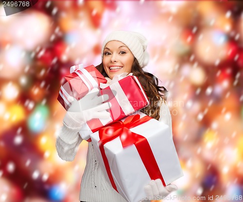 Image of woman in sweater and hat with many gift boxes