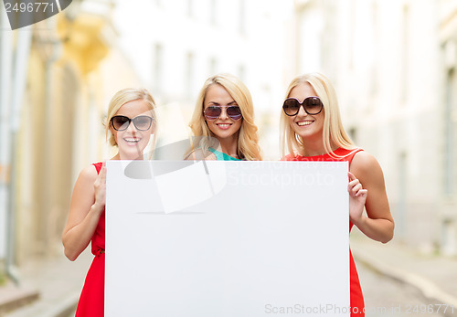 Image of three happy blonde women with blank white board