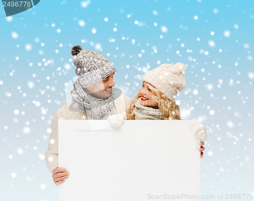 Image of couple in winter clothes with blank white board