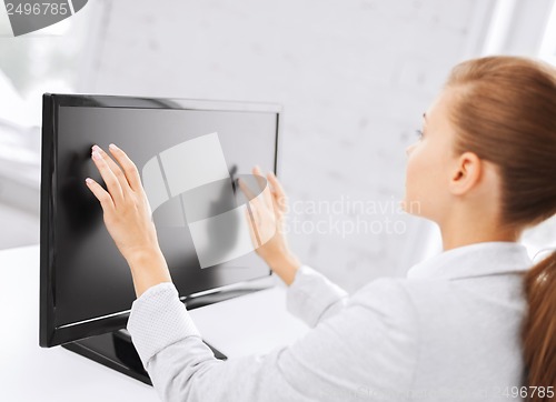 Image of smiling businesswoman with touchscreen in office