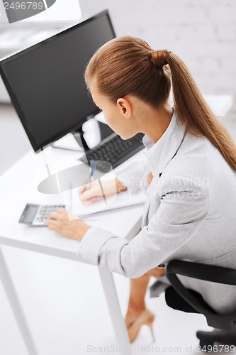 Image of businesswoman with notebook and calculator