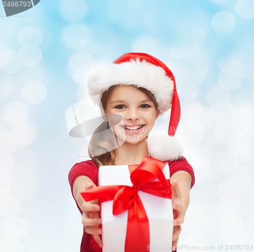 Image of smiling girl in santa helper hat with gift box