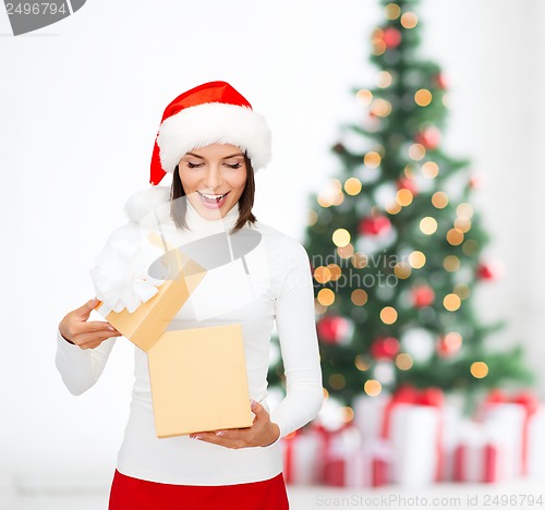 Image of surprised woman in santa helper hat with gift box