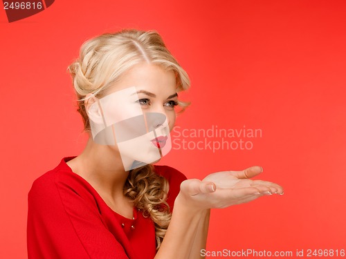 Image of happy woman in red dress blowing on palms