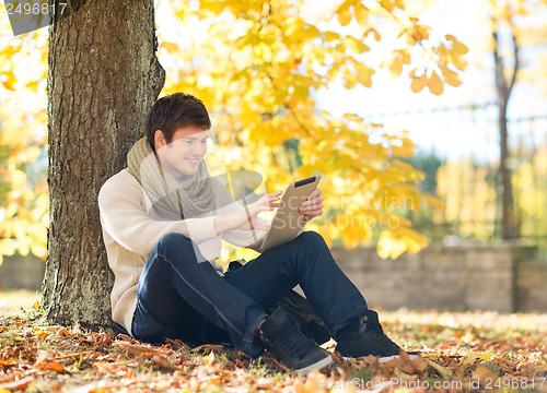 Image of man with tablet pc in autumn park