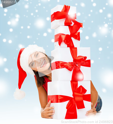 Image of smiling woman in santa helper hat with gift boxes