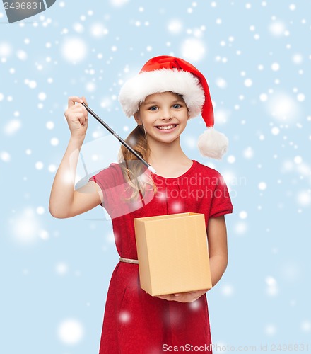 Image of smiling girl in santa helper hat with gift box