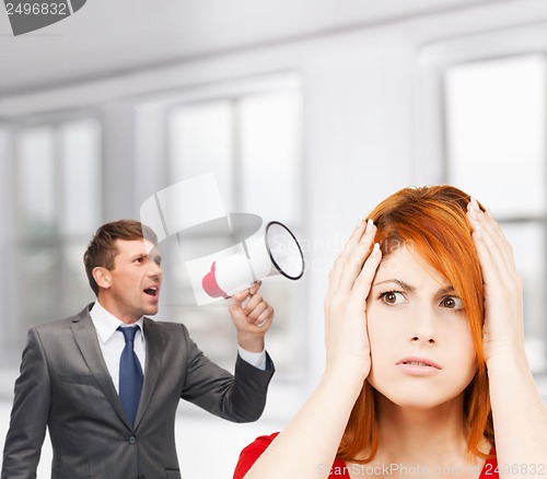 Image of buisnessman with bullhorn and stressed woman