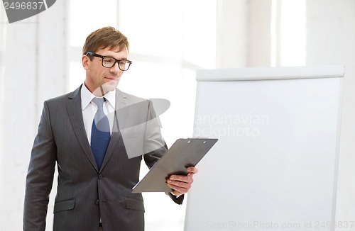 Image of businessman pointing to flip board in office