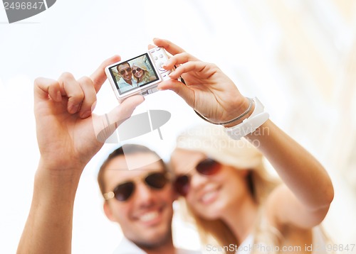 Image of travelling couple taking photo picture with camera