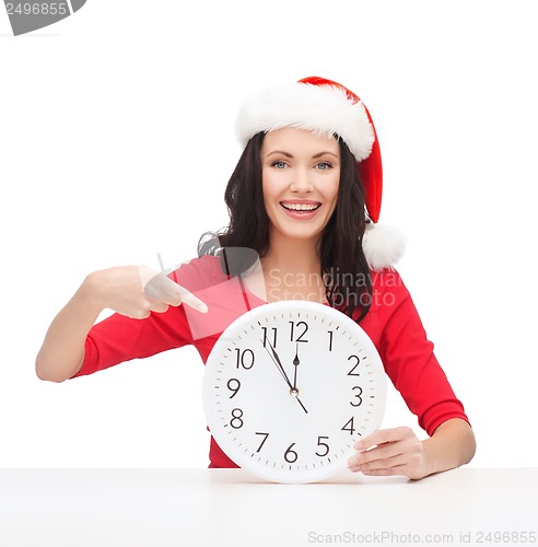 Image of woman in santa helper hat with clock showing 12