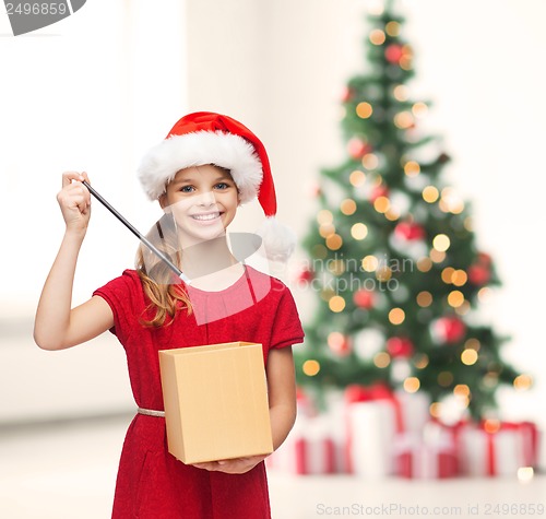 Image of smiling girl in santa helper hat with gift box