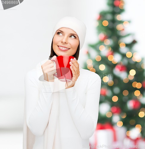 Image of woman in hat with red tea or coffee mug