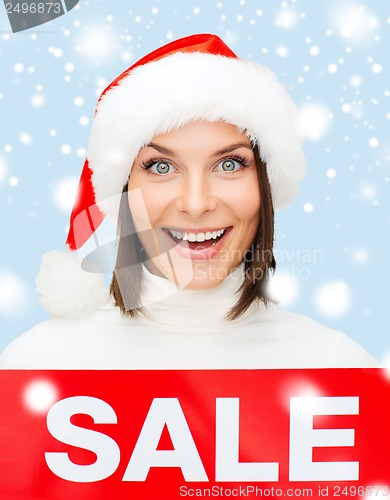 Image of woman in santa helper hat with red sale sign