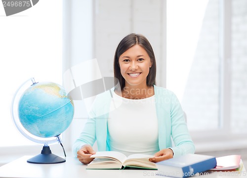 Image of teacher with globe and book at school
