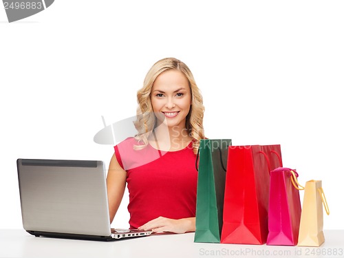 Image of woman with shopping bags and laptop computer