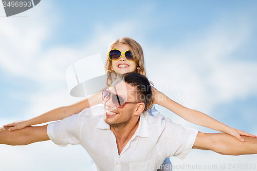 Image of happy father and child in sunglasses over blue sky
