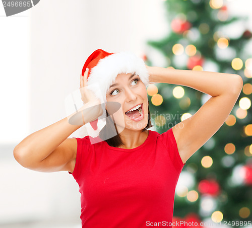 Image of surprised woman in santa helper hat