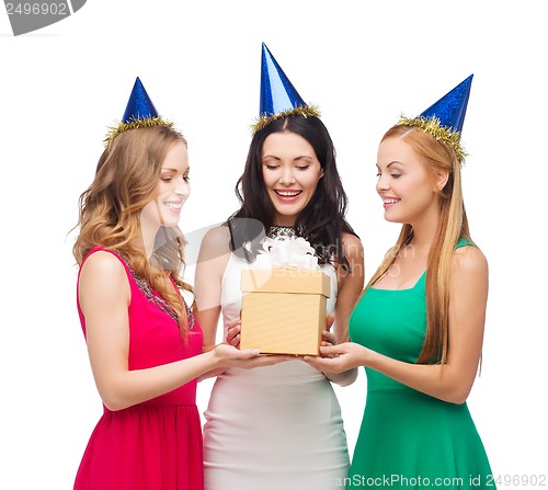 Image of three smiling women in blue hats with gift box