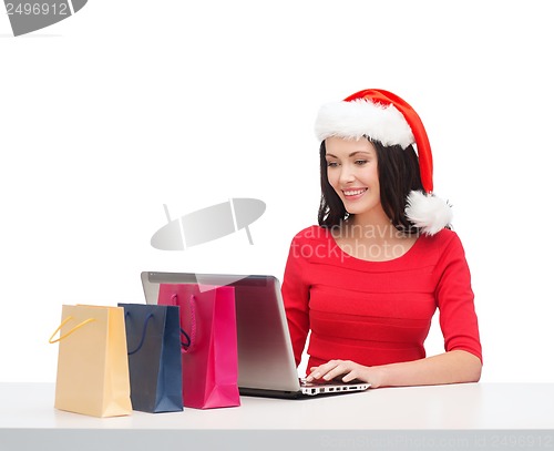 Image of woman with shopping bags and laptop computer