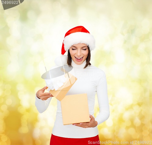 Image of surprised woman in santa helper hat with gift box