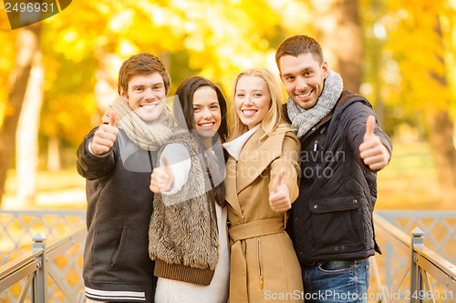 Image of group of friends having fun in autumn park