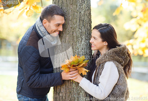 Image of romantic couple playing in the autumn park