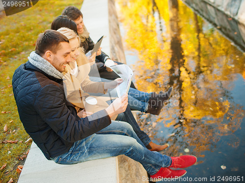 Image of couples with tourist map in autumn park