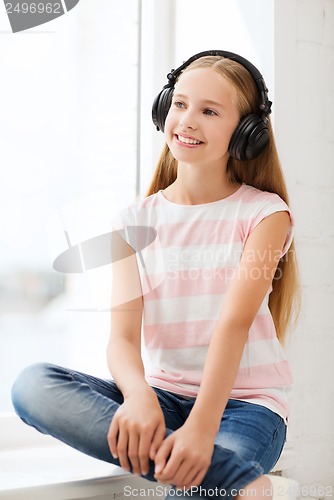 Image of little girl with headphones at home