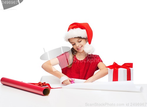 Image of smiling girl in santa helper hat with gift box