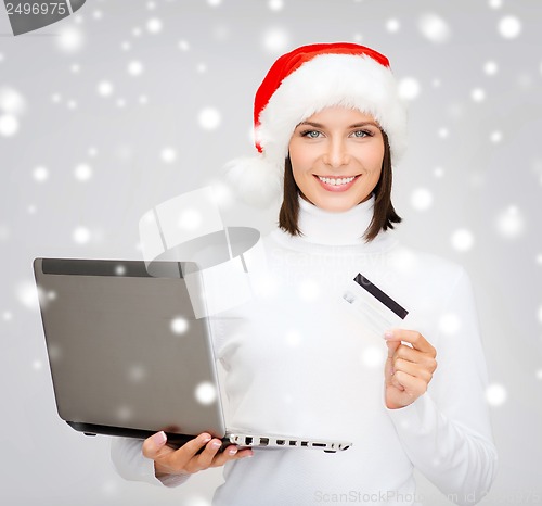 Image of woman in santa hat with laptop and credit card