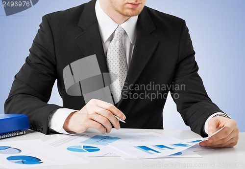 Image of businessman working and signing with papers